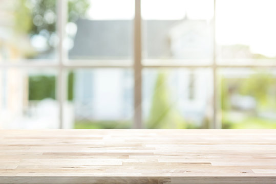 Wood table top with window and morning sunlight in background