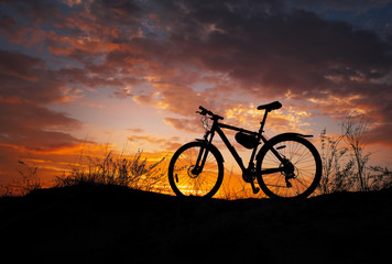 Fototapeta premium Silhouette of a bicycle during sunset. Sandy meadow. No one.