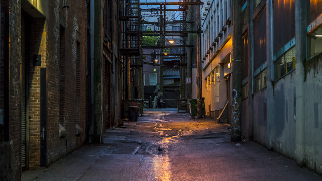 Empty dark and scary back alley. Desolated area in one of the most vibrant cities in North America. The alley is in the vicinity of the well known "Hastings" St. Vancouver, British Columbia. Canada.