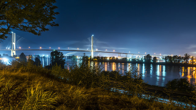 Long exposure at night of Alex Fraser bridge, lights and glitters are seen in the frame. Surrey to Burnaby highway 91. Beautiful British Columbia, Canada.