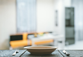 empty plate with fork and knife on wooden table