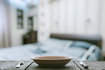 empty plate with fork and knife on wooden table