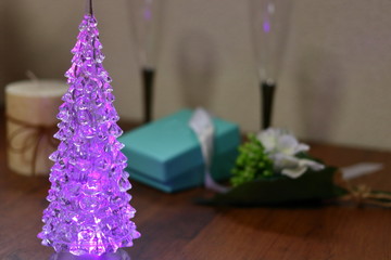 テーブルの上のクリスマスツリーとシャンパングラスとプレゼント