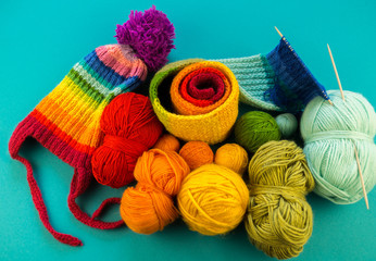 Knitting a rainbow scarf and hat Blue background