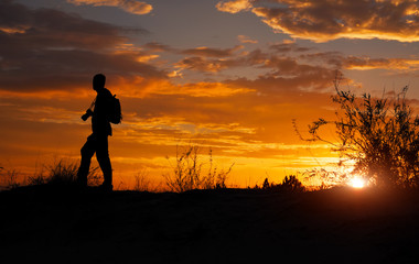 Silhouette of photographer with his camera during sunset