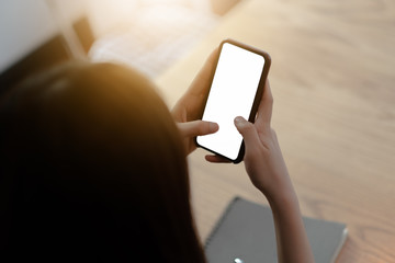 Mockup image of a woman holding mobile phone with blank black screen in modern loft cafe