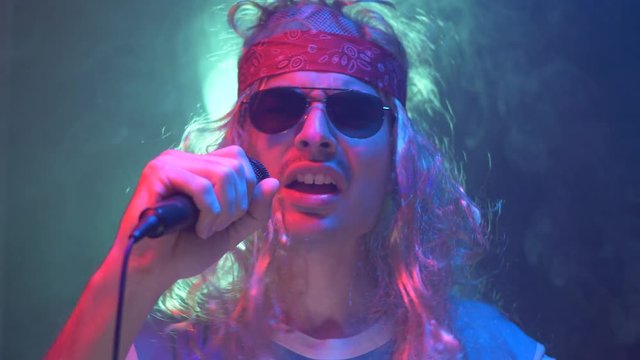 80's rock pop singer singing on a stage live giving a performance dressed like a typical 80's 90's  rockstar.