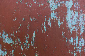 painted iron surface with a large rusty and metal corrosion, chipped paint, old background with peeling and cracking paint