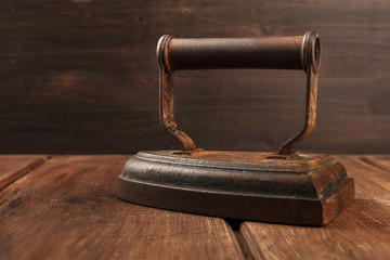 Side view of a vintage iron on a dark background with copy space