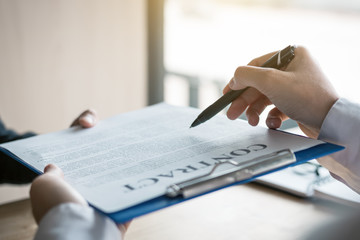 Two business people going through paperwork contract in an office.