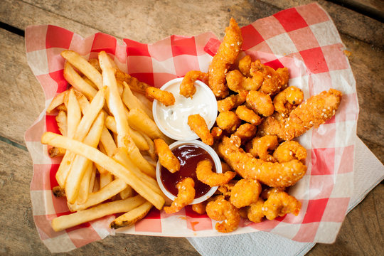 chicken sticks, breaded shrimp and french fries basket 