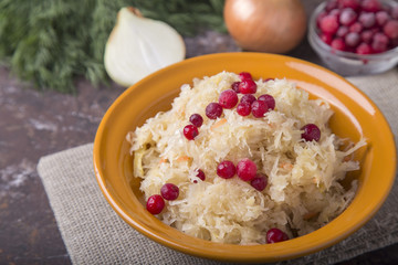 Homemade sauerkraut with berries and onion in a plate.