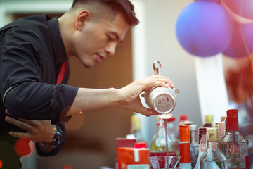 Hand holding mug or jug of mixer of bartender make fruite cocktails to prepare the exciting shot to party, serving cocktails wonderful night holiday outdoor funny