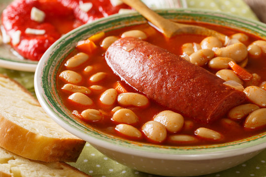 Traditional Balkan food: pasulj bean soup with sausage close-up on a plate. horizontal