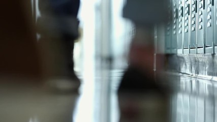 View of students feet walking in school hallway past lockers. - Powered by Adobe
