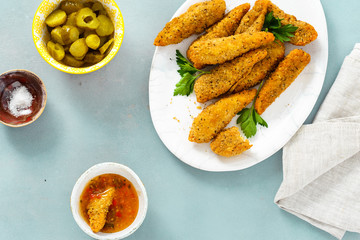 Chicken breast nuggets sour-sweet sauce blue background top view