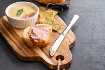Fresh homemade chicken pate with bread on a black background. Copy space.
