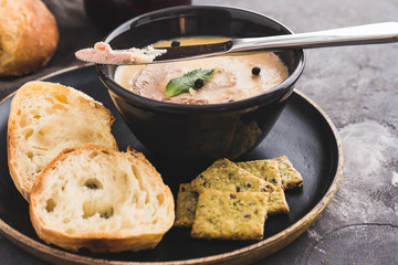 Fresh homemade chicken pate with bread on a black background. Copy space.
