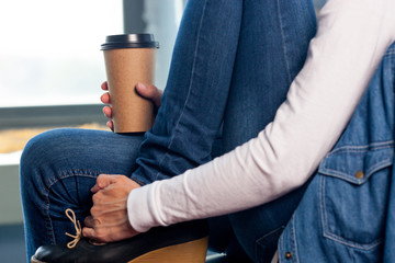 Young woman in white shirt with disposable coffee cup. Youth, modern lifestyle. Coffee break, cosy relaxing moment. 