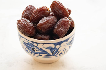 Fresh Medjool Dates in a bowl. Ramadan kareem. White background. Turkish style. Copy space.