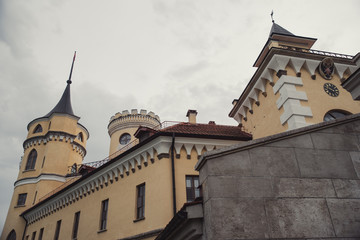 Fototapeta na wymiar Yellow castle with brown roof in cloudy weather