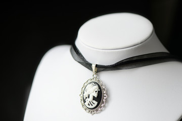 Halloween necklace with skeleton cameo pendant on a dark background close up