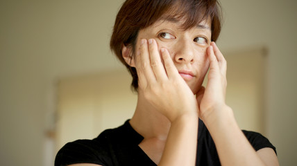 頬に手を当てる女性