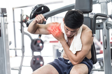 Asian man have injury muscle joint between shoulder and arm pain after workout in gym,Healthcare concept