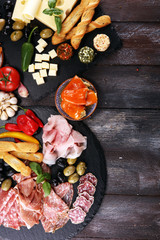 Italian antipasti wine snacks set. Cheese variety, Mediterranean olives, pickles, Prosciutto di Parma, tomatoes, artichokes.