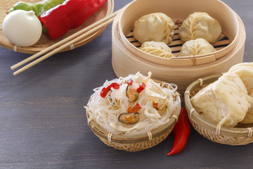 Traditional Asian food - steam dumplings, noodles with seafood, vegetables. Copy space