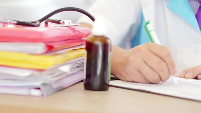 Close-up of male doctor making a prescription in his cabinet