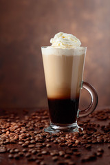Coffee drink or cocktail with cream on a brown background.