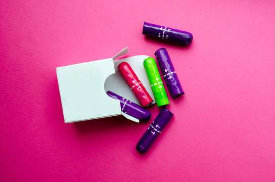  white box with multi-colored tampons on a pink background