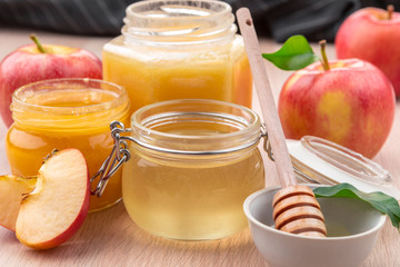 Jewish holiday Rosh Hashanah background with honey and apples on wooden table.