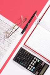 Office table with pen, calculator and glasses. Colour