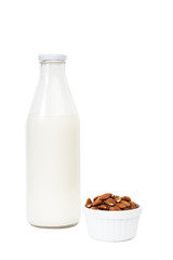 Botella de leche de almendras con cuenco con almendras naturales sobre fondo blanco aislado. Vista de frente. Copy space
