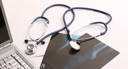 laptop ,stethoscope and x-ray on the table