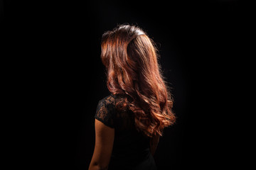 Brunette long hair black dressed on dark background