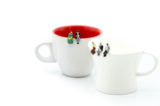 Miniature people : People sitting on cup using for concept of Native American Day.