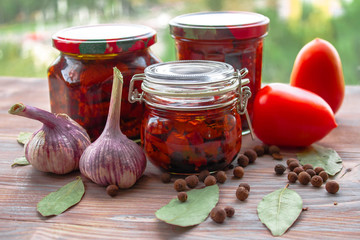 Sundried tomatoes cut into slices with salt, oregano, Basil, thyme, garlic being dried out in the...