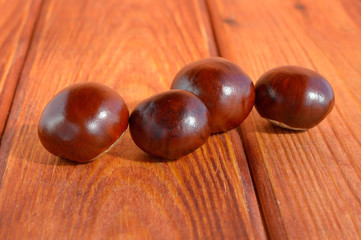 Chestnuts in a row on a wooden background