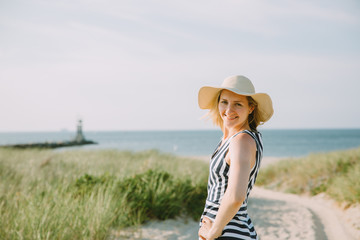 Portrait of a young woman in a straw hat on the beach