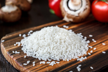 Bunch of rice on a wooden kitchen board.
