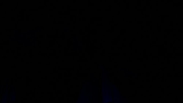 Dancing girl fan silhouettes on concert flashing light cheerful hands in air