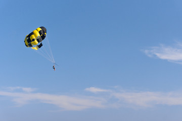 parasailing. the man is flying with a yellow parachute. close-up