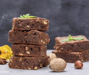 stack of baked square pieces of chocolate brownie pie with walnuts