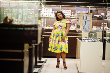Cute small height african american girl with dreadlocks, wear at coloured yellow dress, on watches...