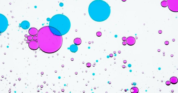 Dosed Mixing of Substances. Bright colored bubbles slowly move around the white background and change their size and shape