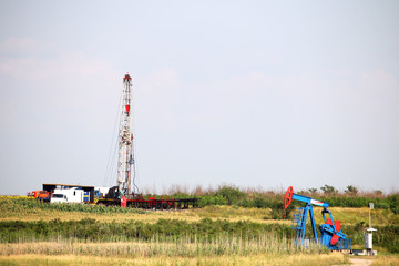 oil drilling rig and pump jack on oilfield