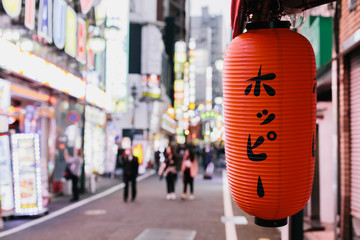 A lantern in front of a bar on a street full of neon lights in Tokyo's red light district called...